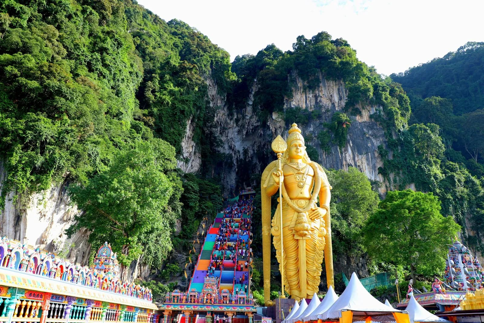 The large golden statue at Batu Caves in front of the limestone hill