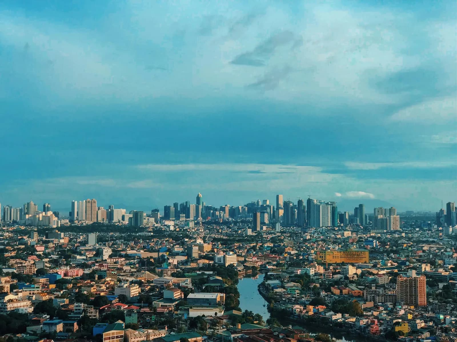The Manila skyline of high-rise towers under a clear blue sky